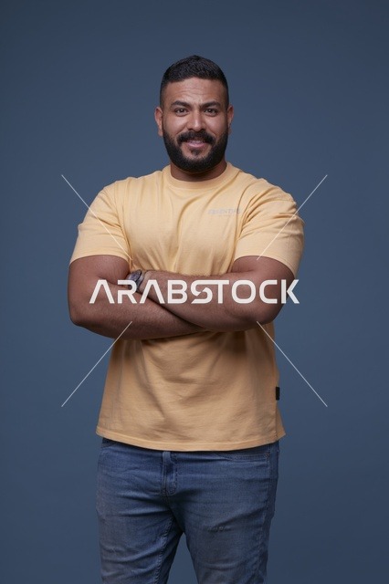 بورتريه لرجل سعودي مبتسم بملابس كاجوال خلفية زرقاء