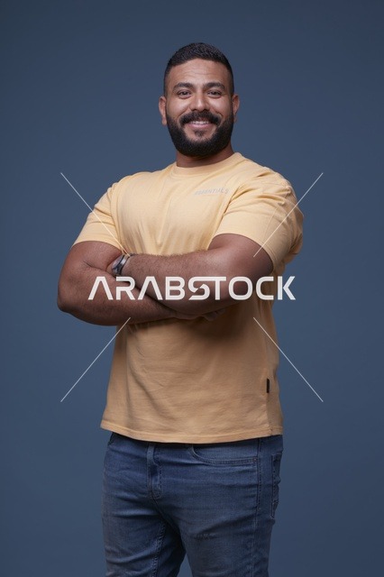 بورتريه لرجل سعودي مبتسم بتيشيرت أصفر في الاستوديو