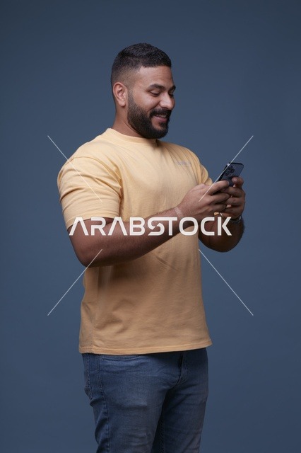 رجل سعودي يستخدم الهاتف الذكي بخلفية زرقاء