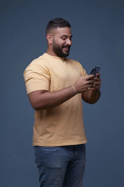Saudi Man Using Smartphone on Blue Background