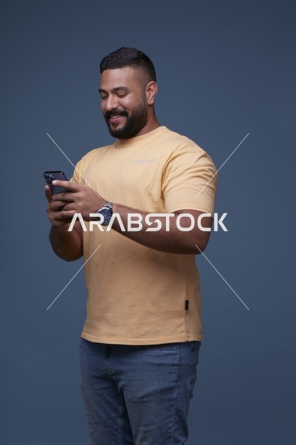 رجل سعودي يكتب على الهاتف الذكي في استوديو