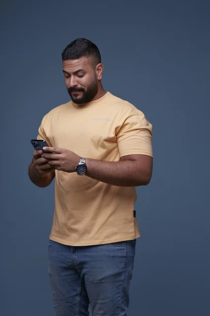 Saudi Man in Casual Clothing Using Smartphone