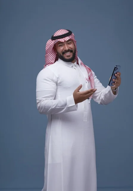 Smiling Saudi Man in Traditional Dress with Smartphone