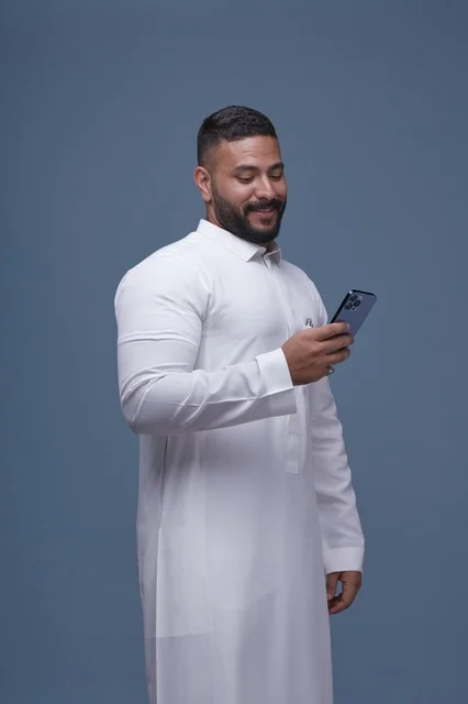 Saudi Man Using Smartphone in White Thobe