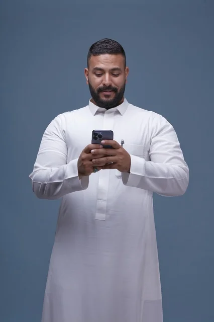 Saudi Man Using Smartphone in White Thobe