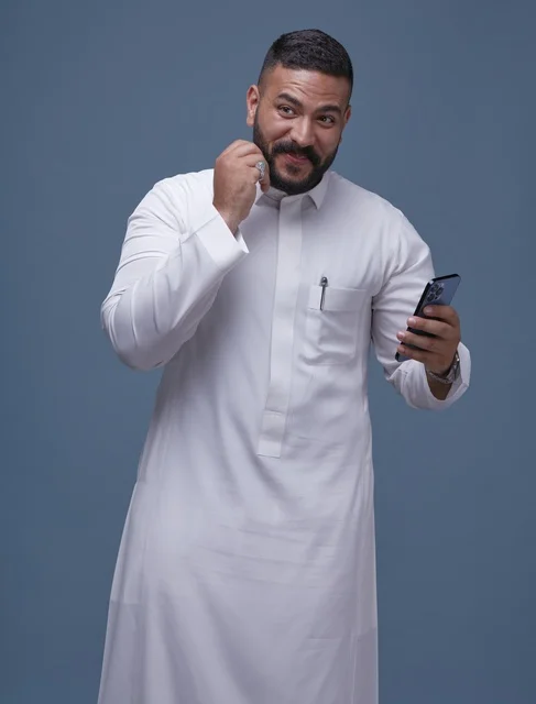رجل سعودي بالثوب الأبيض يستخدم الهاتف الذكي