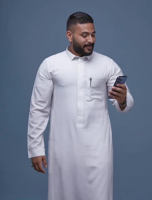 Saudi Man in White Thobe Using Smartphone Studio Background
