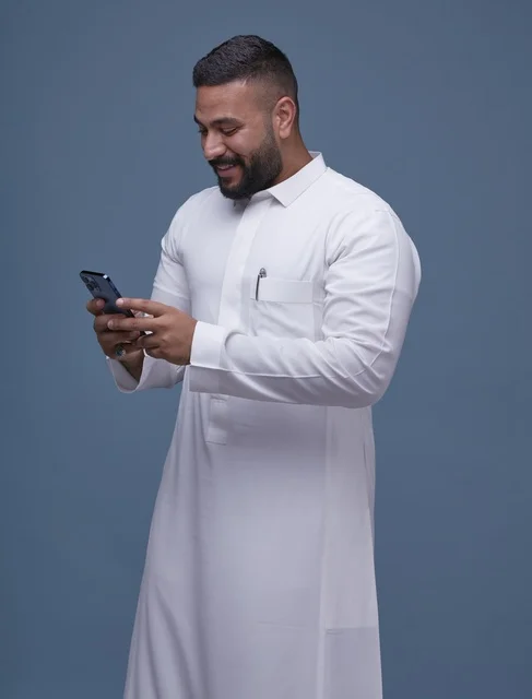 Saudi Man in White Thobe Using Smartphone Studio Shot