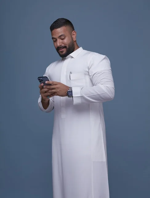 Saudi Man in White Thobe Using Smartphone Portrait
