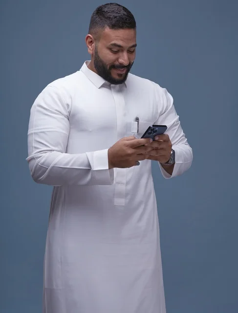 Saudi Man in White Thobe Using Smartphone Studio Shot
