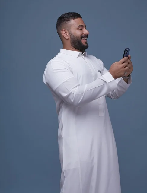 Saudi Man Using Smartphone in White Thobe