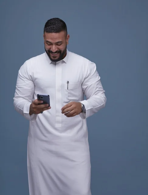 Saudi Man in White Thobe Using Smartphone Studio Shot