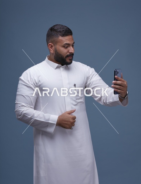 رجل سعودي بالثوب الأبيض يلتقط صورة سيلفي