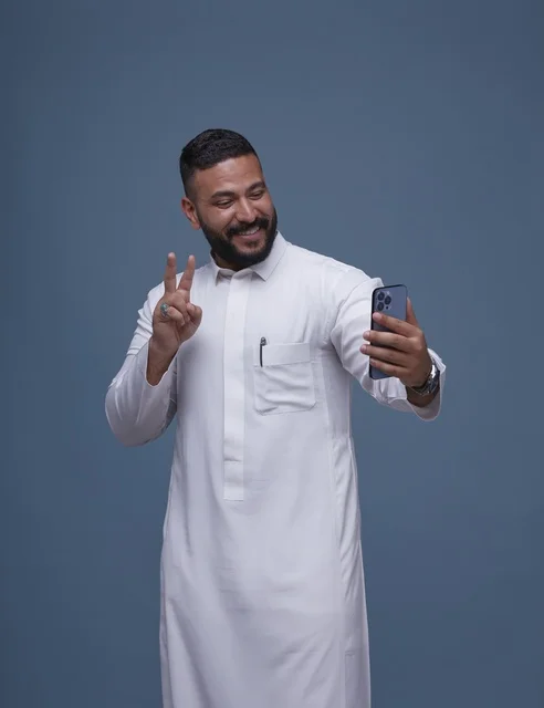 Smiling Saudi Man Taking Selfie in White Thobe