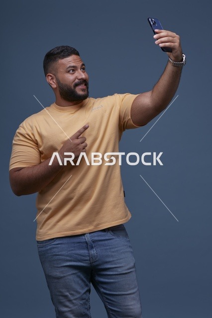 رجل سعودي يلتقط صورة سيلفي بملابس كاجوال