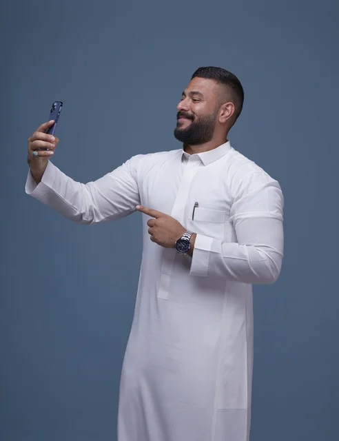 رجل سعودي يلتقط سيلفي بالثوب الأبيض في استوديو