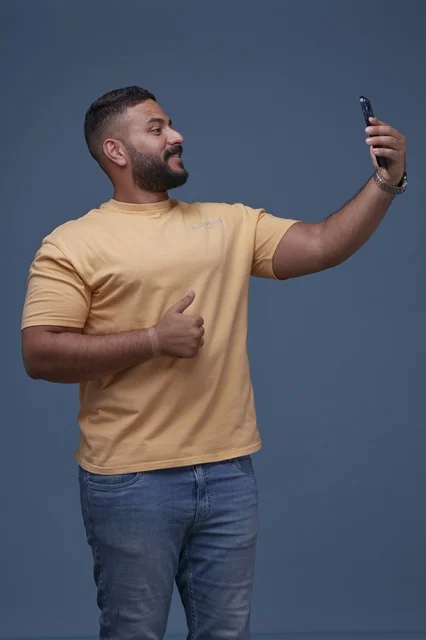 Saudi Man Taking Selfie with Thumbs Up Gesture in Studio