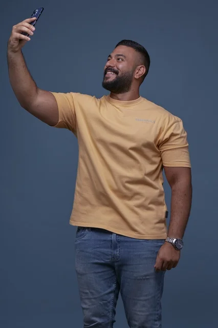رجل سعودي يلتقط سيلفي بالهاتف بملابس كاجوال