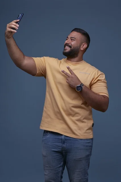 Saudi Man Taking Selfie with Peace Sign in Studio