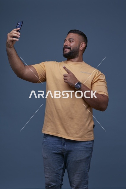 رجل سعودي يلتقط سيلفي بالهاتف بملابس كاجوال