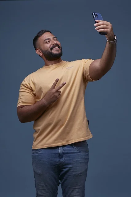Saudi Man Taking Selfie with Peace Sign on Blue Background