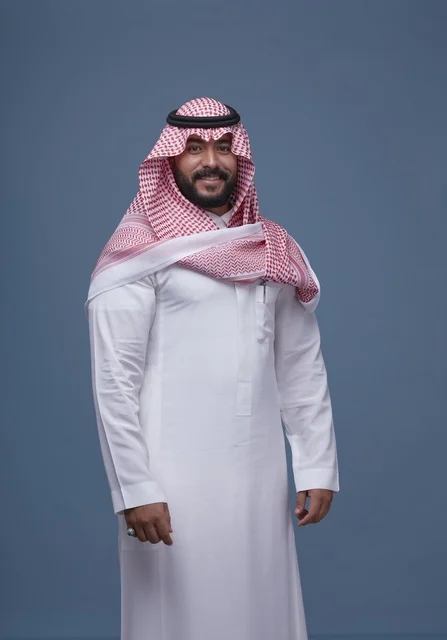 رجل سعودي بالزي التقليدي في الاستوديو بخلفية زرقاء