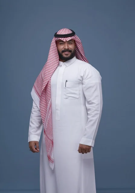 رجل سعودي بالزي التقليدي في استوديو بخلفية زرقاء