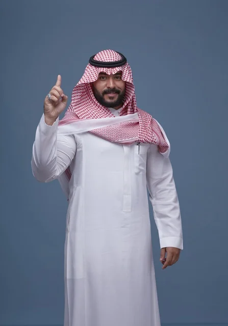 Saudi Man in Traditional Attire Pointing Up in Studio