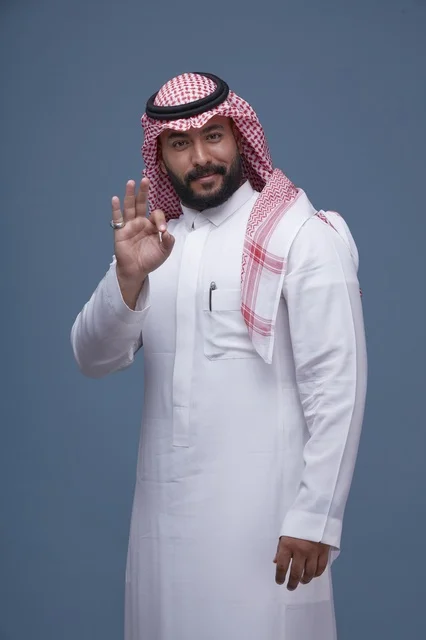 رجل سعودي بالزي التقليدي يشير بعلامة التمام
