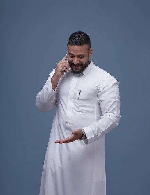 Saudi Man in White Thobe Talking on Smartphone Studio