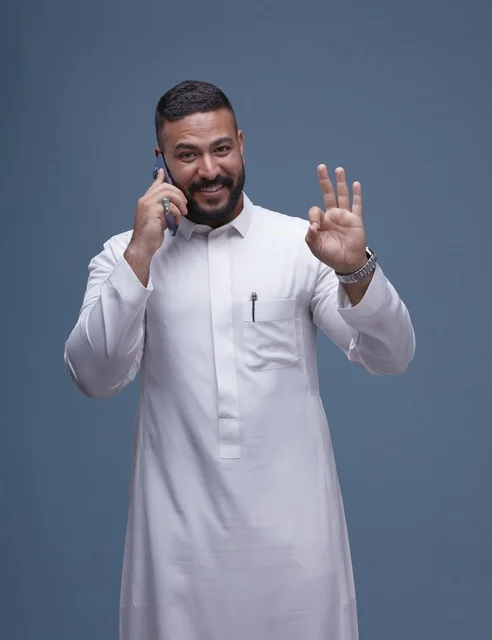 Saudi Man in White Thobe Talking on Smartphone Studio Shot