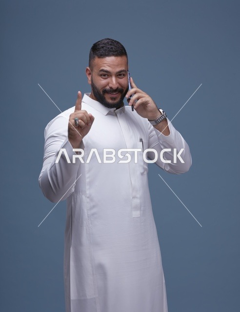 رجل سعودي بالثوب الأبيض يتحدث بالهاتف الذكي استوديو