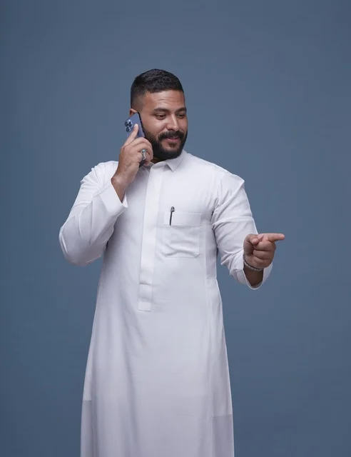 Saudi Man in White Thobe Talking on Smartphone Studio