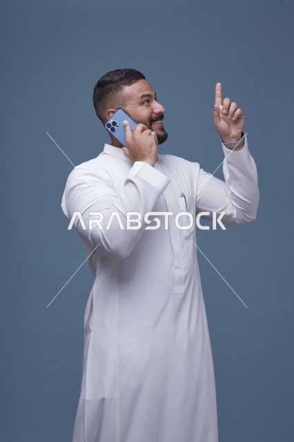 رجل سعودي بالثوب الأبيض يستخدم الهاتف الذكي