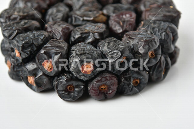 A close-up image of layers of healthy Ajwa dates, a meal with a high nutritional value, Ramadan hospitality, types of healthy and delicious dates, Ajwa dates, white background