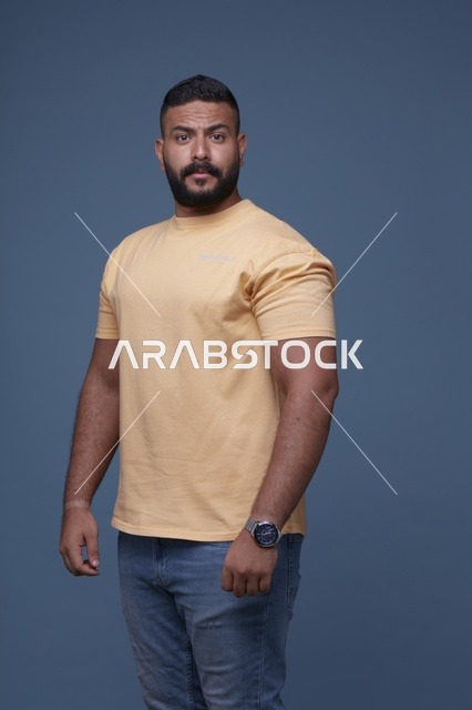 رجل سعودي بتيشيرت أصفر على خلفية زرقاء