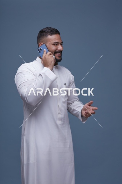 رجل سعودي بالثوب الأبيض يتحدث عبر الهاتف الذكي استوديو