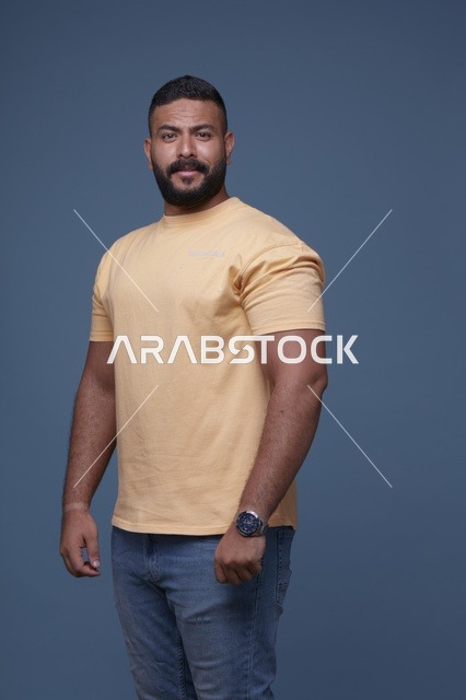 بورتريه رجل سعودي مبتسم بتيشيرت أصفر في الاستوديو
