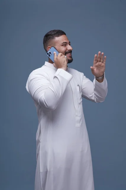 Saudi Man in White Thobe Talking on Smartphone Saudi Man in White Thobe Talking on Smartphone