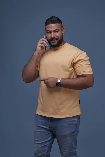 Smiling Saudi Man in Studio Talking on Smartphone