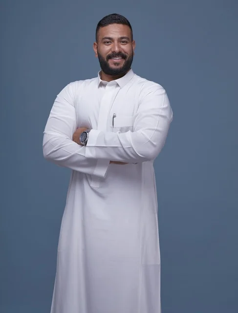 Saudi Man in White Thob Standing with Crossed Arms