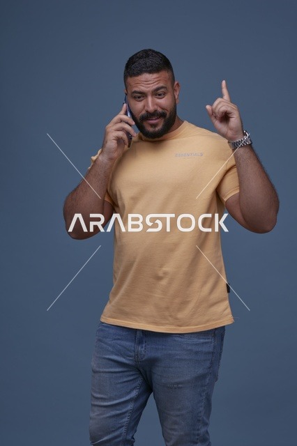 رجل سعودي مبتسم يتحدث بالجوال في الاستوديو