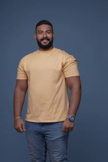 بورتريه لرجل سعودي مبتسم بتيشيرت أصفر كاجوال تصوير استوديو
