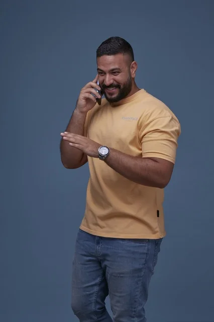 رجل سعودي يتحدث عبر الهاتف المحمول في الاستوديو