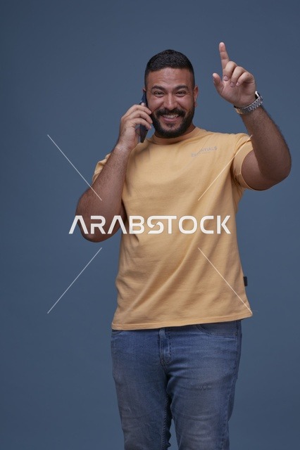 رجل سعودي مبتسم يتحدث عبر الهاتف في الاستوديو