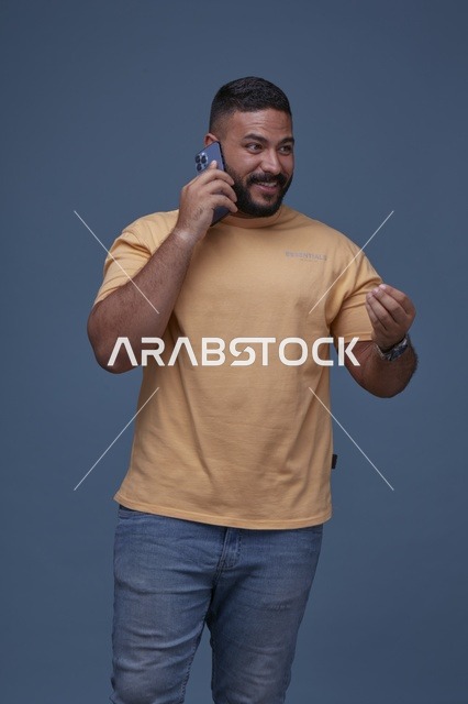 رجل سعودي مبتسم يتحدث عبر الهاتف في الاستوديو