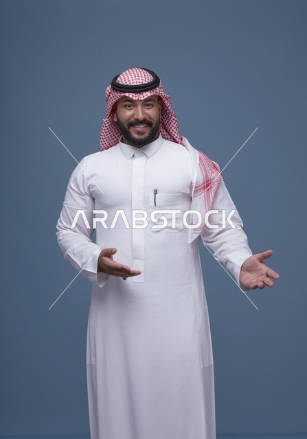 رجل سعودي بالثوب والشماغ بحركة ترحيبية في الاستوديو
