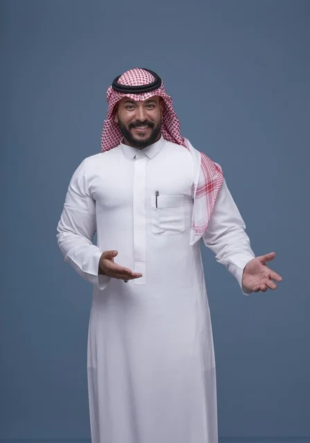 رجل سعودي بالثوب والشماغ بحركة ترحيبية في الاستوديو