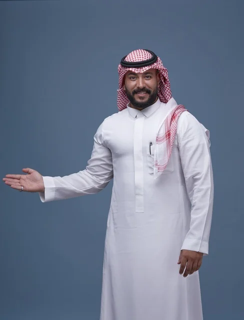 رجل سعودي بالثوب التقليدي يشير بيده بورتريه استوديو