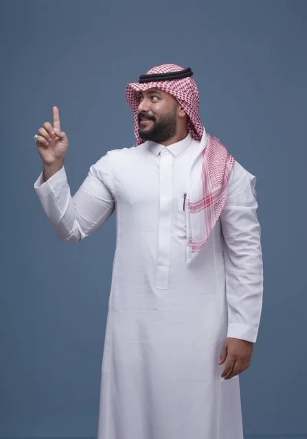 Saudi Man in Traditional Thobe Pointing Up in Studio